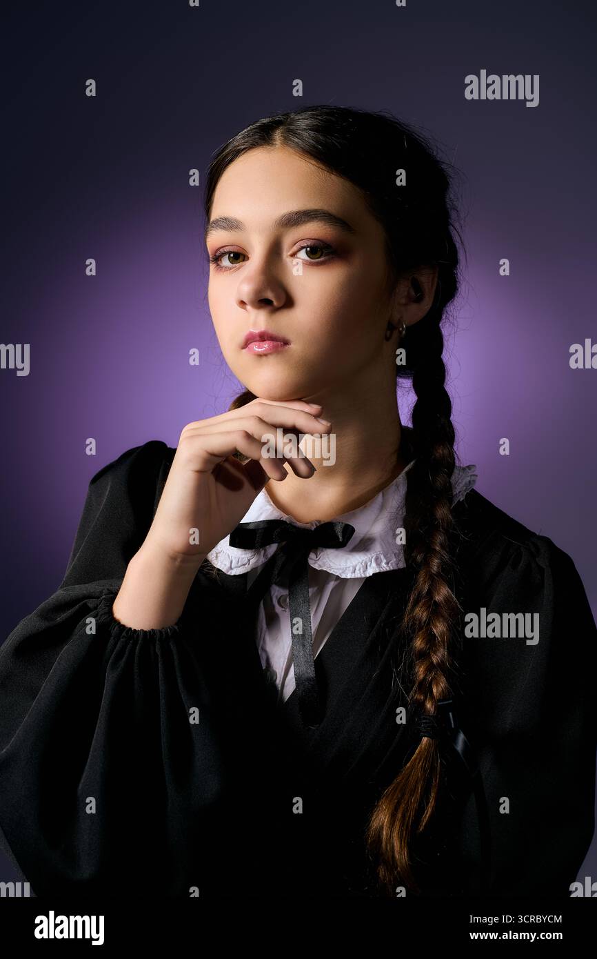 Una ragazza con trecce indossa un abito in stile gotico, evocando un inquietante personaggio del mercoledì per Halloween. Foto Stock