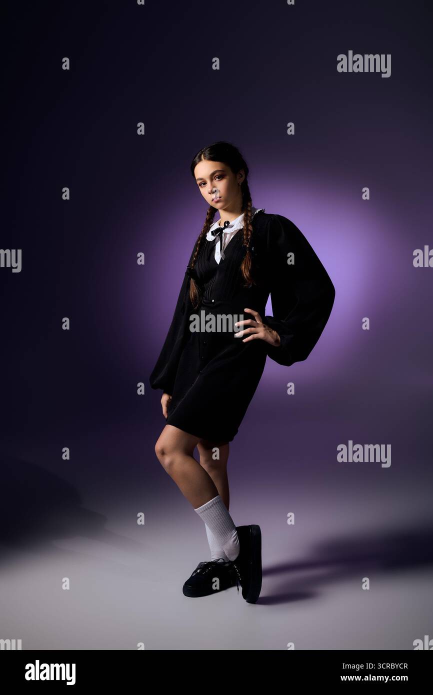 Una ragazza in treccia indossa un abito gotico del mercoledì che cattura lo spirito di Halloween. Foto Stock