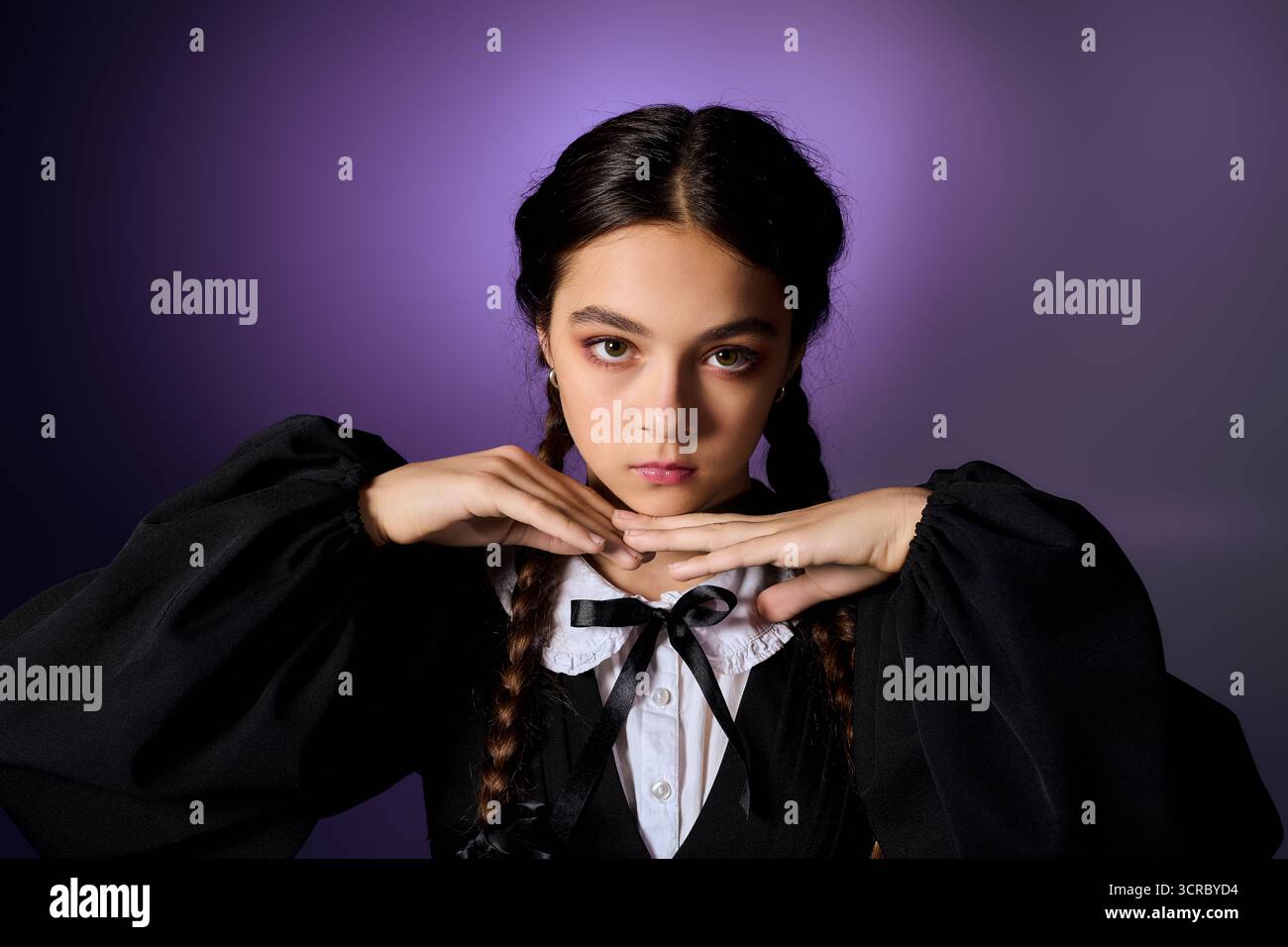 Una ragazza con trecce indossa un abito gotico che incarna un personaggio del mercoledì durante le festività autunnali. Foto Stock