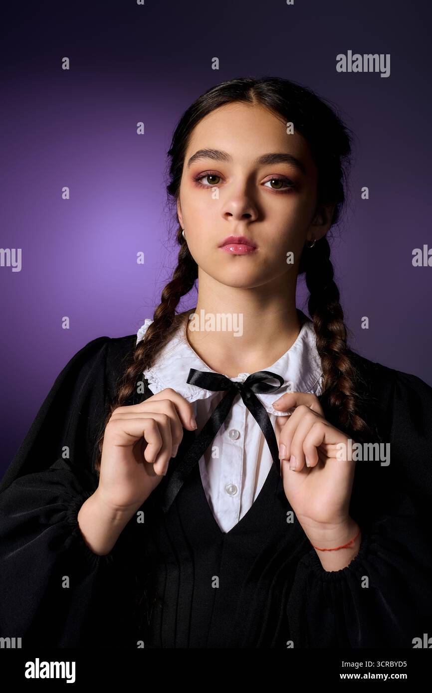 Una ragazza con trecce indossa un abito in stile gotico del mercoledì, che abbraccia lo spirito di Halloween. Foto Stock