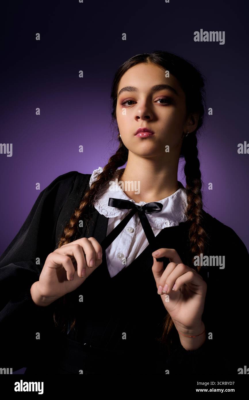 Una ragazza in treccia indossa un abito gotico del personaggio del mercoledì, catturando lo spirito autunnale di Halloween. Foto Stock