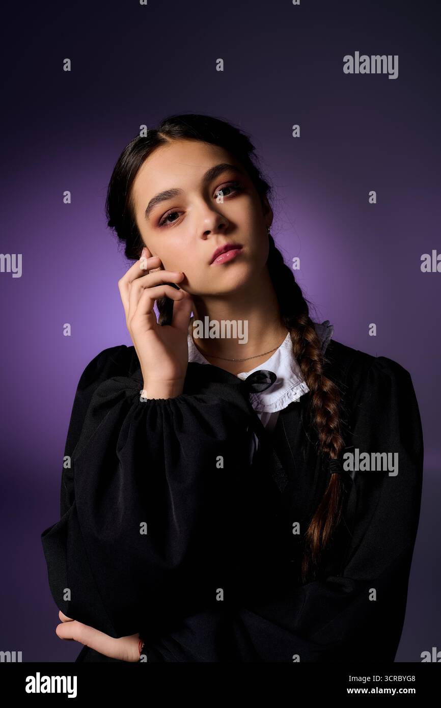 Una ragazza in treccia indossa un abito gotico ispirato a un personaggio del mercoledì per Halloween. Foto Stock