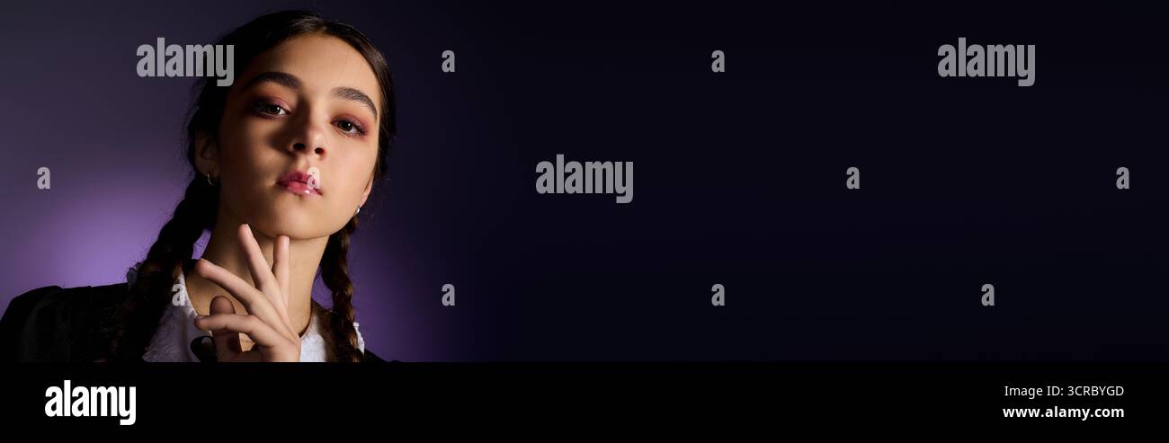 Una ragazza con i capelli intrecciati indossa un abito gotico ispirato al mercoledì, che abbraccia le vibrazioni di Halloween e lo striscione Foto Stock