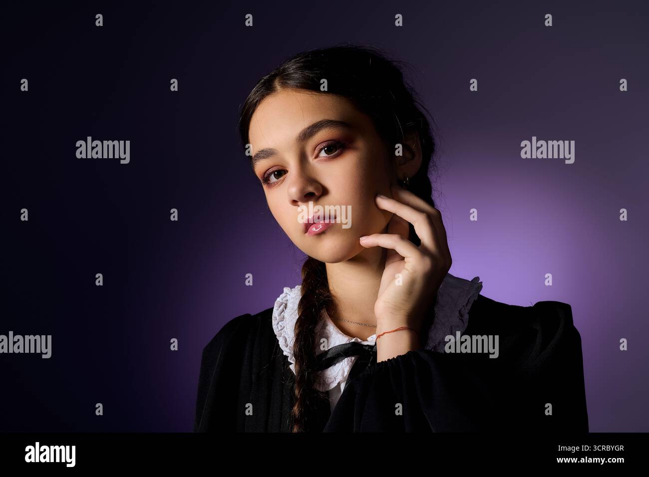 Una ragazza con trecce indossa elegantemente un abito gotico, catturando l'essenza del personaggio di mercoledì. Foto Stock