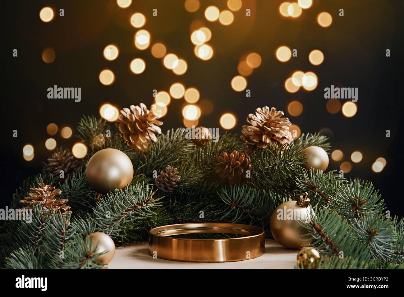 Lussuoso podio dorato con rami di pino e luci natalizie Foto Stock