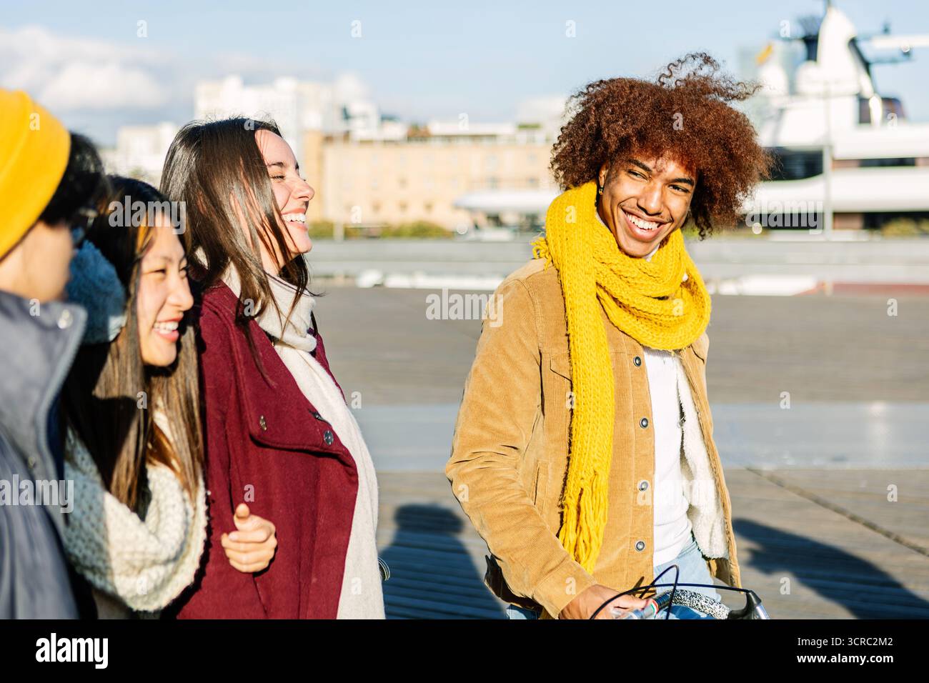 Felici amici multietnici che camminano insieme nelle soleggiate giornate invernali Foto Stock