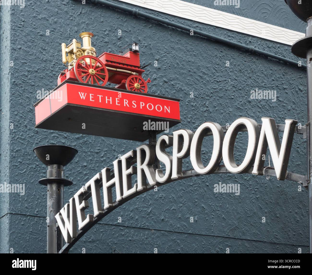 Un modello di un pompiere d'epoca sopra il cartello di Wetherspoon per il pub Fire Station di Whitley Bay Foto Stock