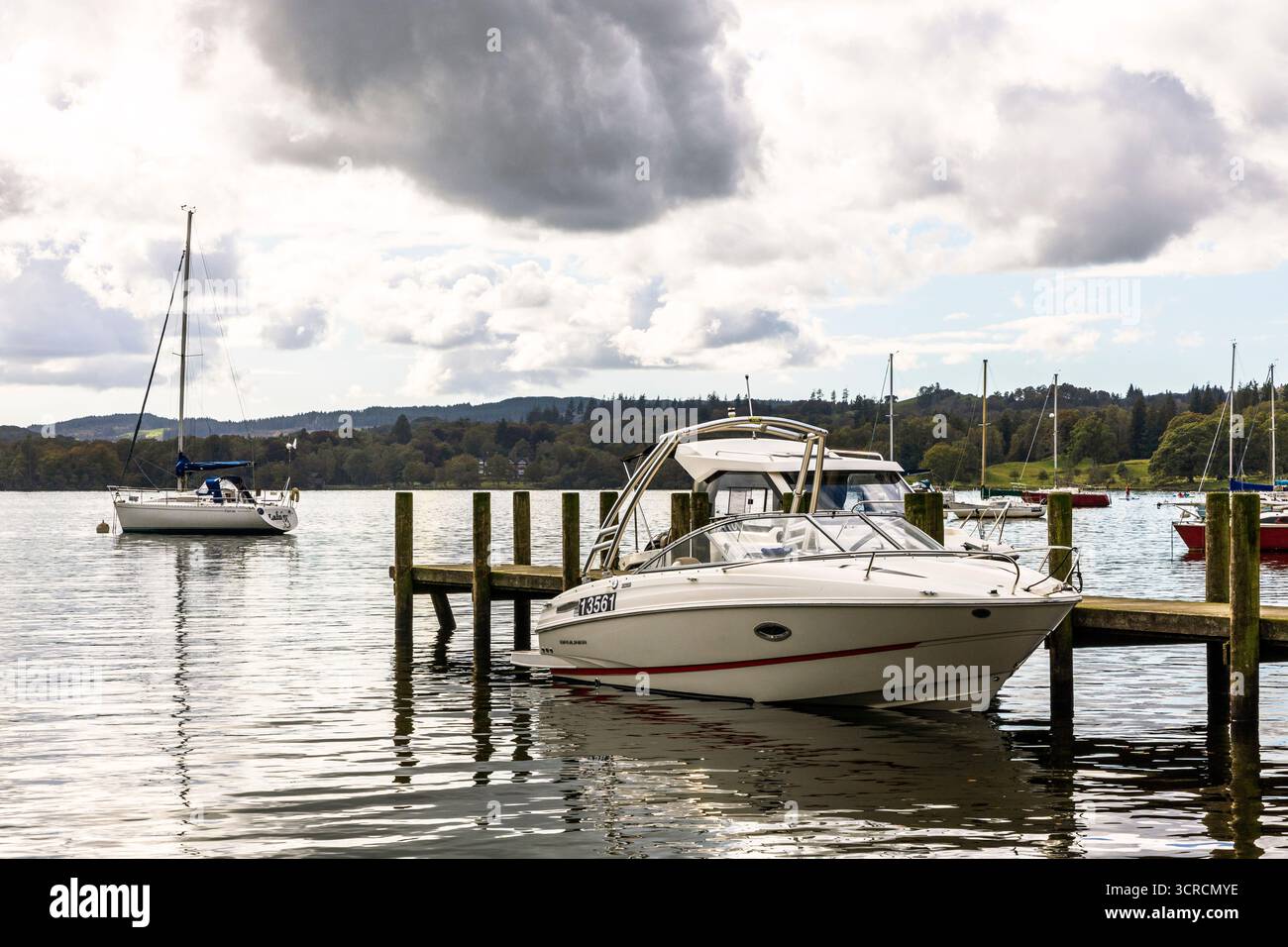 Molo in legno e barche a motore ormeggiate a Waterhead, Ambleside, lago Windermere, Lake District, Inghilterra, REGNO UNITO Foto Stock