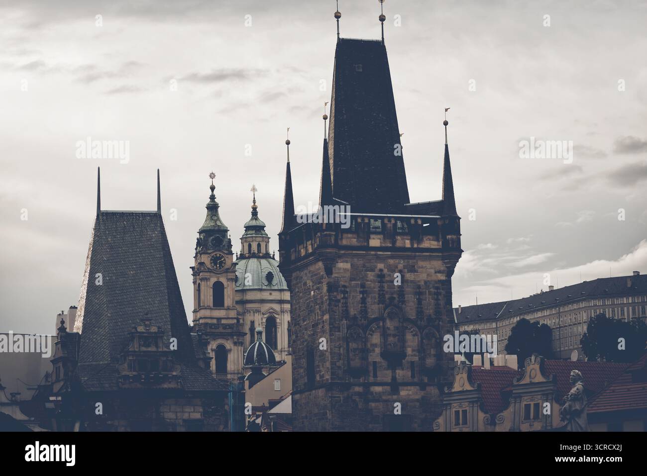 La maestosa torre del ponte della città Vecchia si affaccia sugli affascinanti tetti di Praga in una giornata nuvolosa, mostrando una ricca storia e una splendida architettura. REP. Ceca Foto Stock