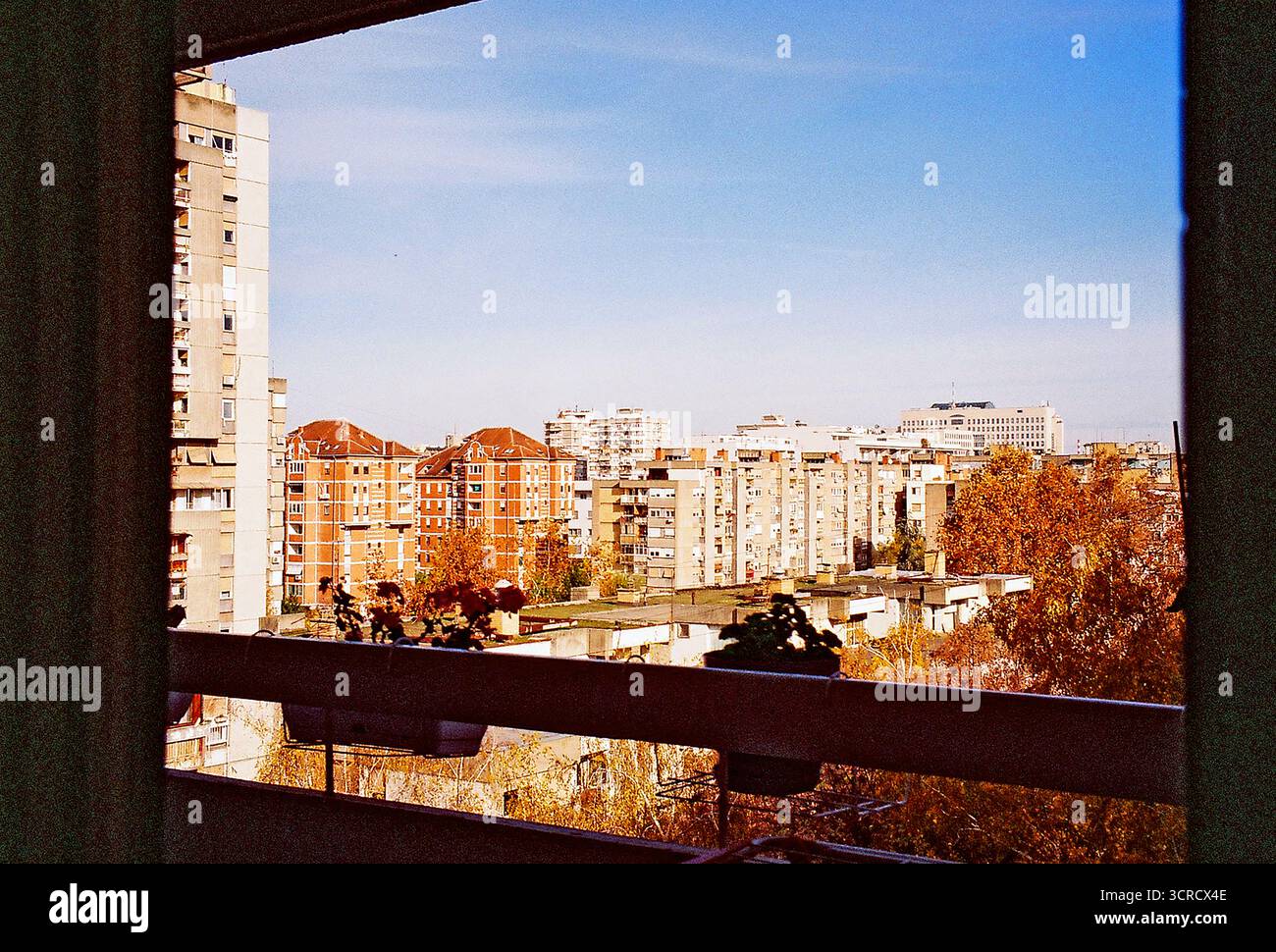 Foto di archivio analogica dall'interno di un appartamento dell'era socialista, che guarda ai brutalisti blocchi abitativi. Architettura soleggiata, grezza e ripetitiva. Foto Stock