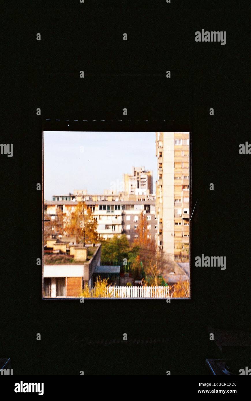 Foto di archivio analogica dall'interno di un appartamento dell'era socialista, che guarda ai brutalisti blocchi abitativi. Architettura soleggiata, grezza e ripetitiva. Foto Stock