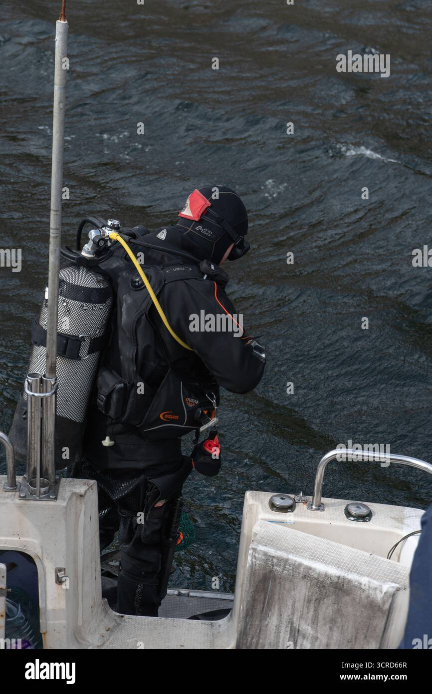 Mare di Barents, Russia - 14 giugno 2025: Il subacqueo regola la maschera prima di entrare nelle fredde acque settentrionali. Foto Stock