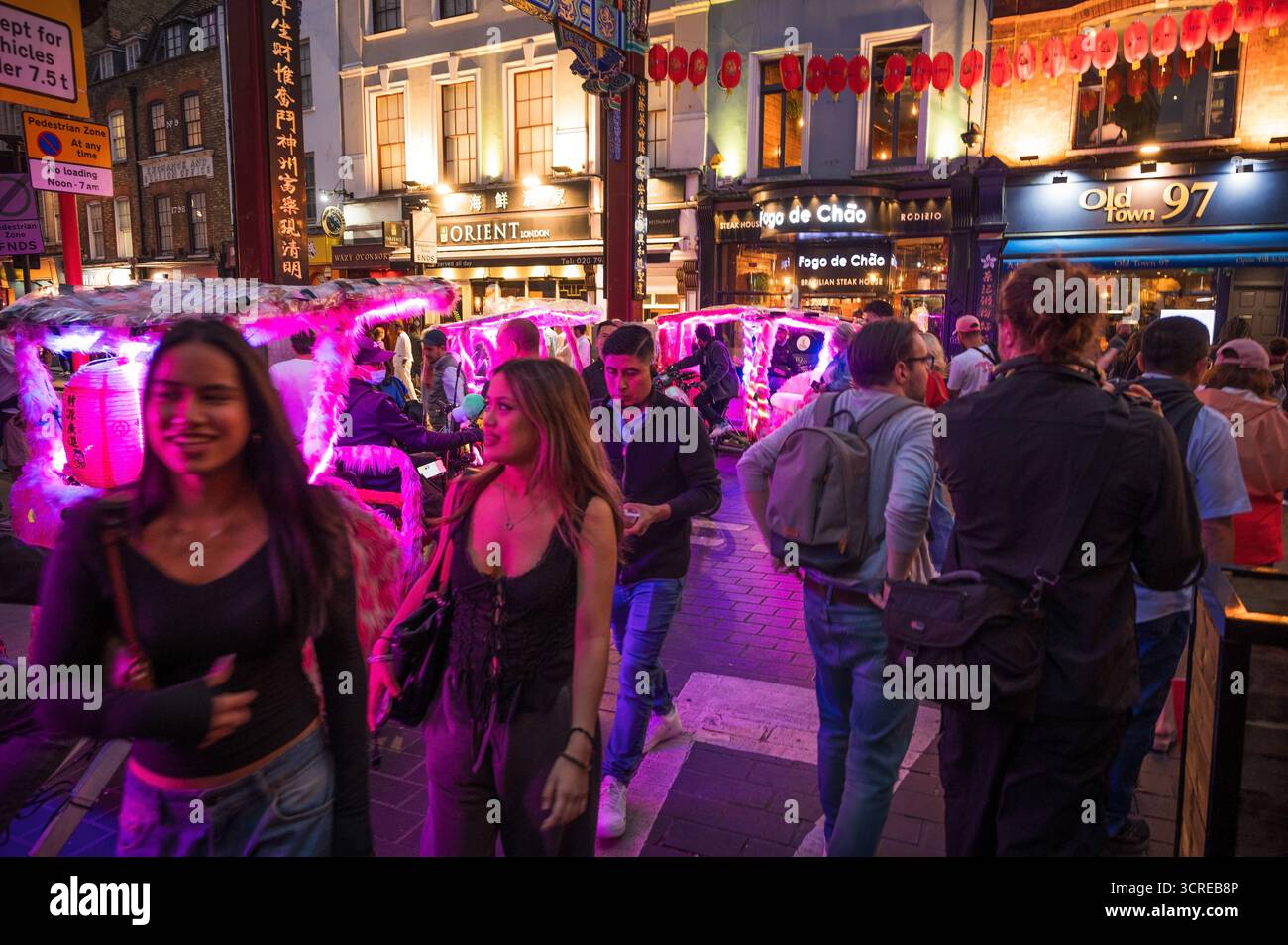 Turisti nei quartieri di SoHo e Chinatown a Londra. Vicino a Piccadilly Circus e Leicester Square, nel centro di Londra di notte. Foto Stock