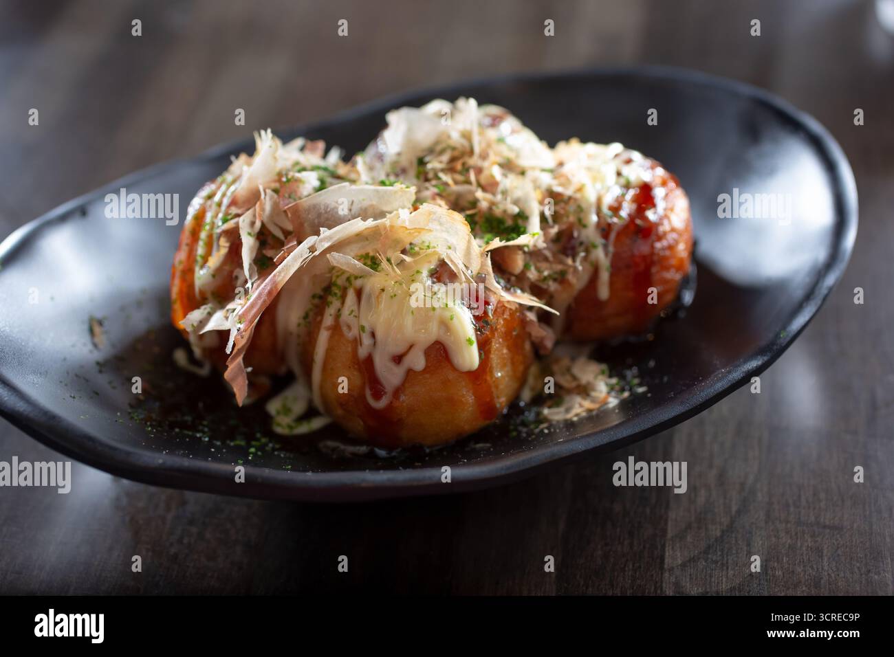 Una vista di un piatto di takoyaki, che è palle di polpo fritte in profondità giapponesi. Foto Stock