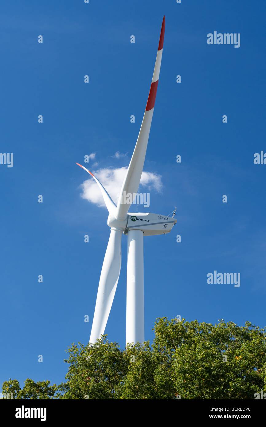 Turbina eolica con pale rotanti contro il cielo blu e gli alberi a Beringen, Limburgo, Belgio, 28 settembre 2025. Foto Stock Turbina eolica con pale rotanti contro il cielo blu e gli alberi a Beringen, Limburgo, Belgio, 28 settembre 2025. Foto Stock