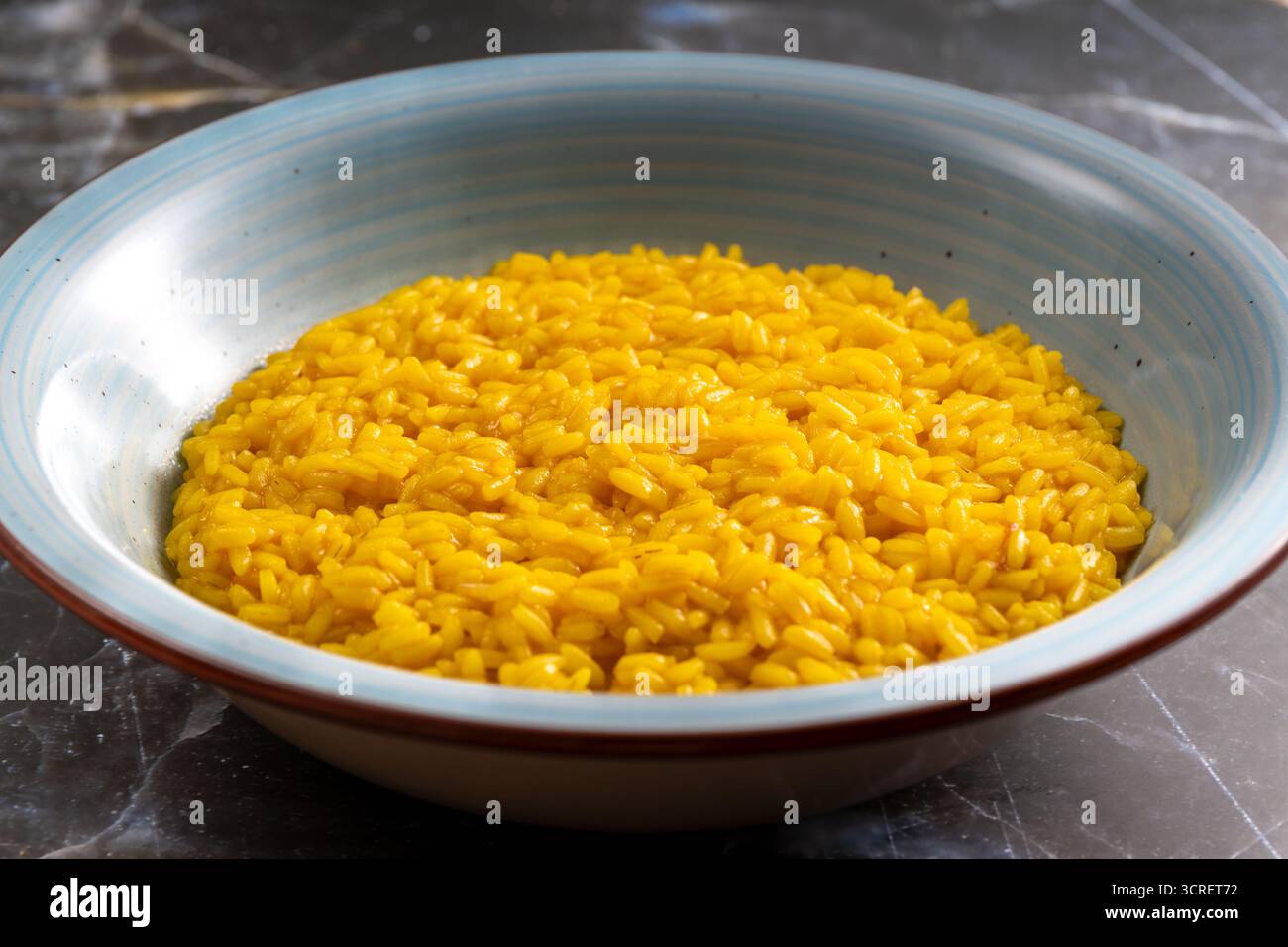 Cremoso risotto italiano che presenta un classico piatto gourmet su sfondo scuro Foto Stock