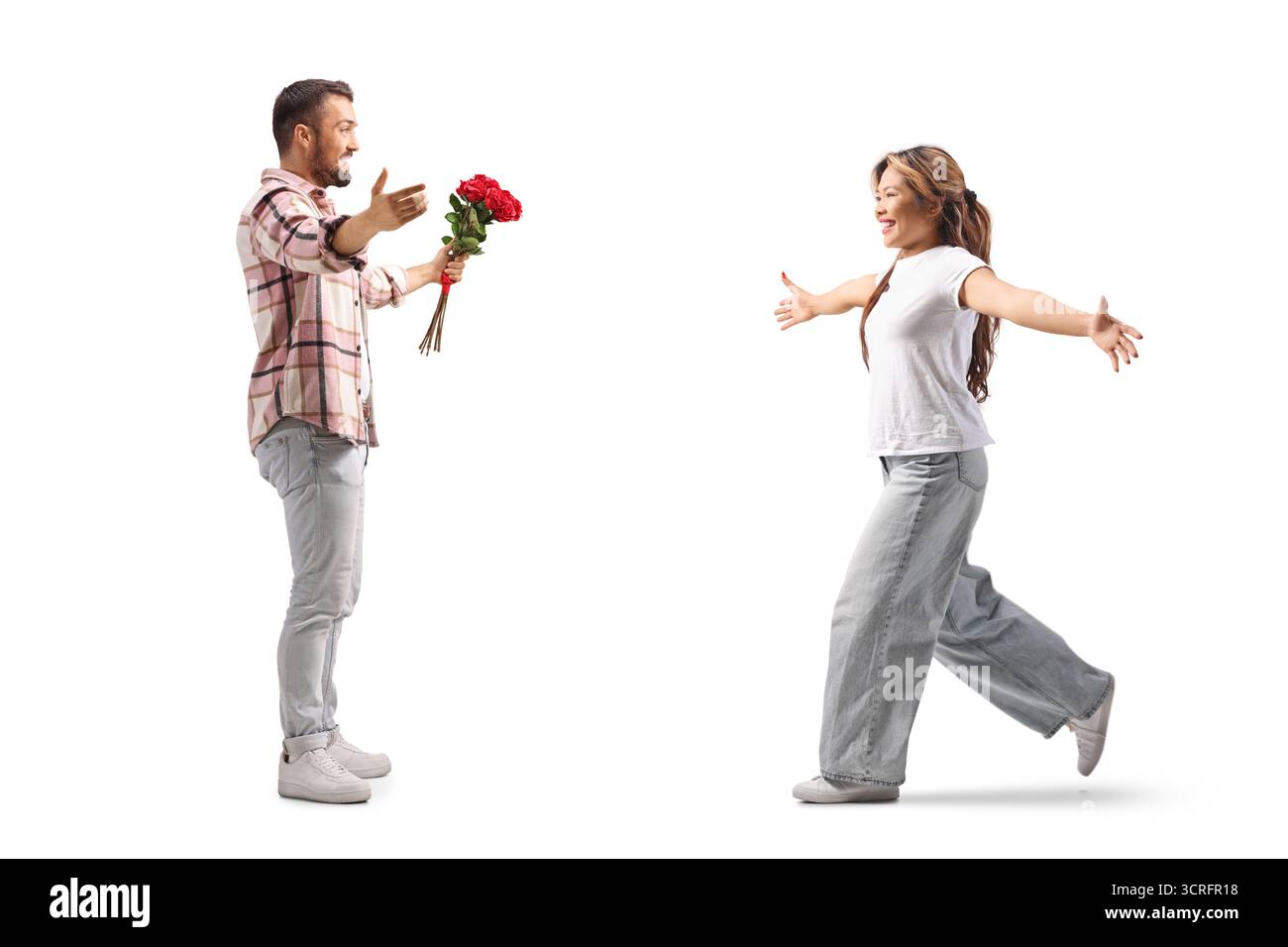 Foto a tutta lunghezza di un uomo che incontra una donna asiatica e tiene un mucchio di rose rosse isolate su sfondo bianco Foto Stock