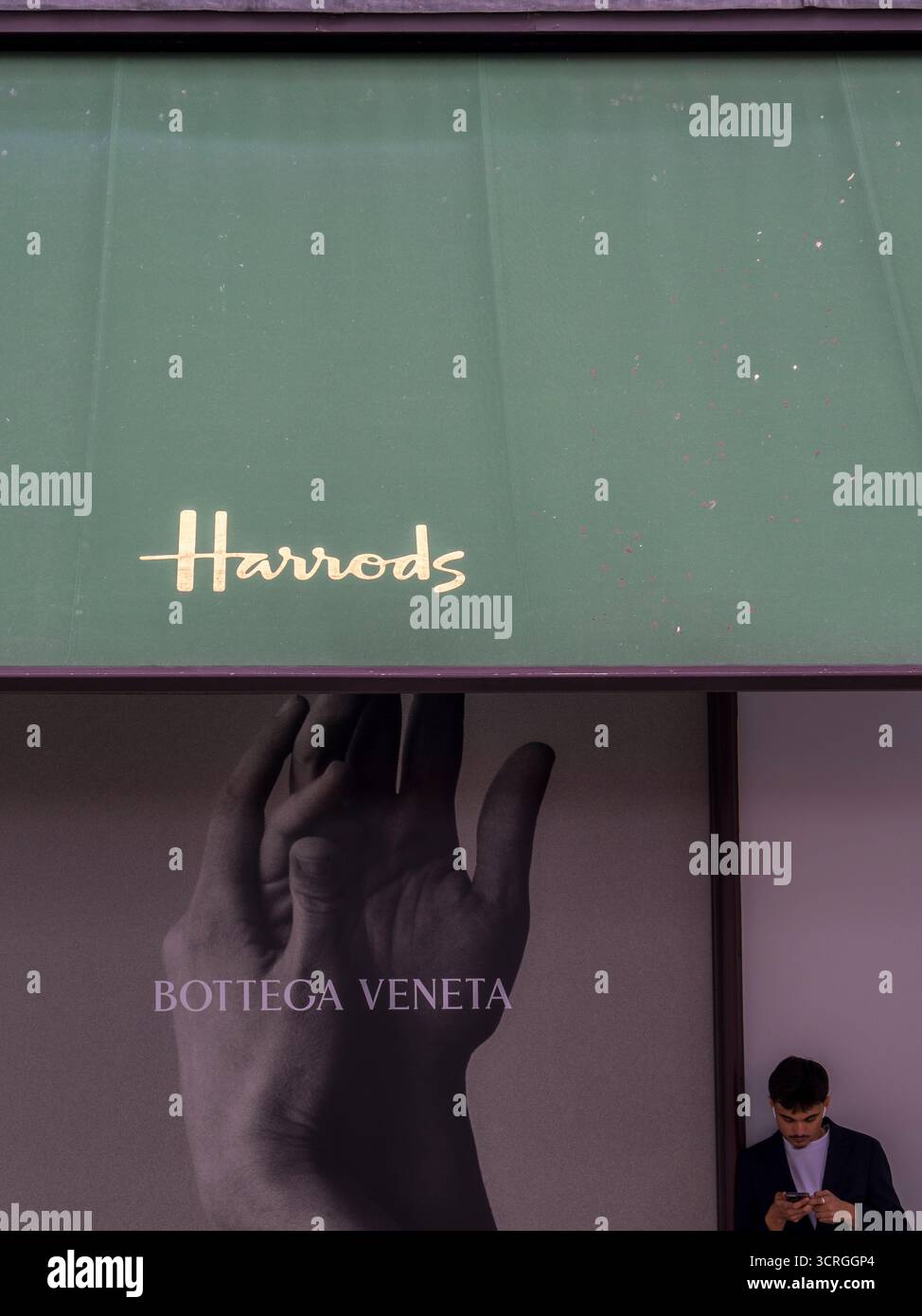 Uomo che riposa fuori Harrods, Londra, Inghilterra, Regno Unito, Gran Bretagna. Foto Stock