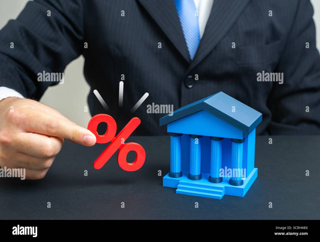 Un uomo d'affari ha interessi vicino a un edificio di una banca. Inflazione e depositi. Concetto di crescita del capitale, rischi monetari, risparmi, prestiti, politica economica, Foto Stock