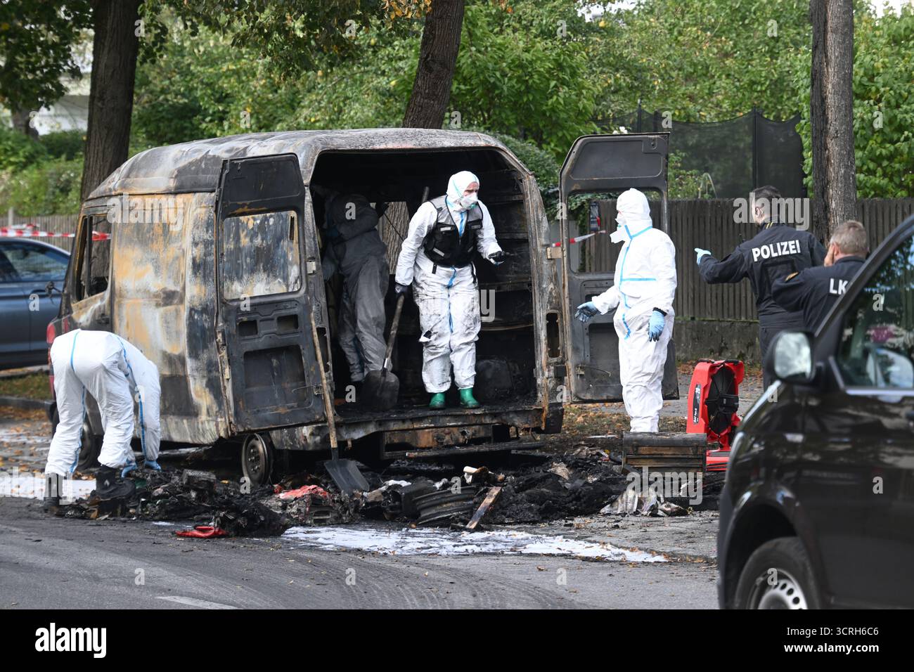 Monaco, Germania. 1 ottobre 2025. Gli investigatori forensi esaminano un furgone bruciato dopo un incendio in una casa indipendente nel quartiere Lerchenau di Monaco. La polizia sta assumendo un background privato. Si dice che un uomo di 57 anni di Starnberg abbia incendiato la casa a nord di Monaco e abbia piantato trappole esplosive. Crediti: Felix Hörhager/dpa/Alamy Live News Foto Stock