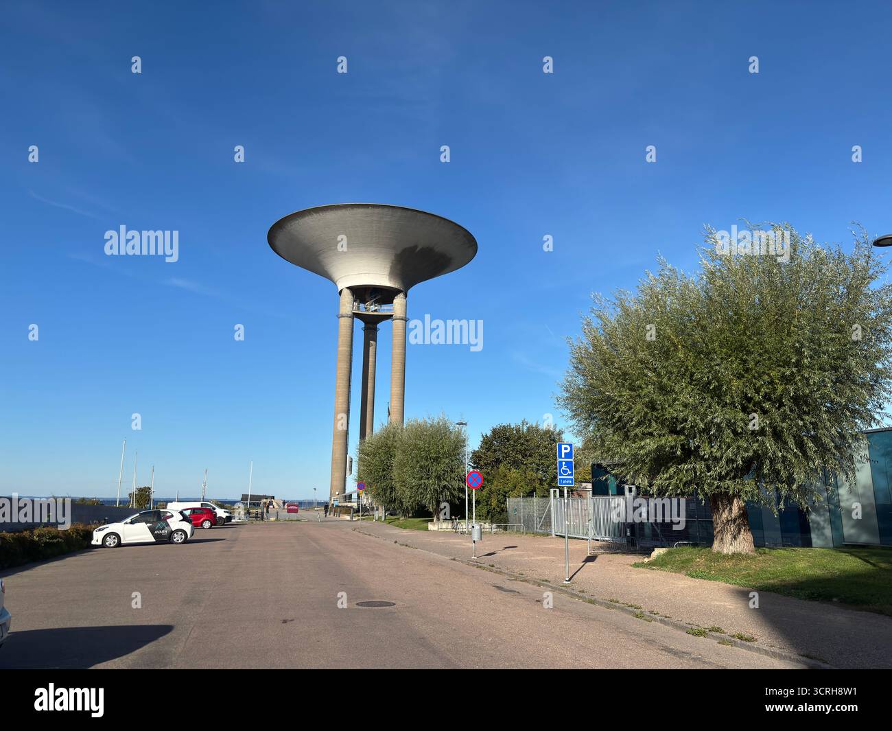 La concrete Landskrona Water Tower in Svezia, costruita nel 1970, presenta un'ampia base di piattini su supporti sottili e un serbatoio visibile sullo skyline costiero Foto Stock