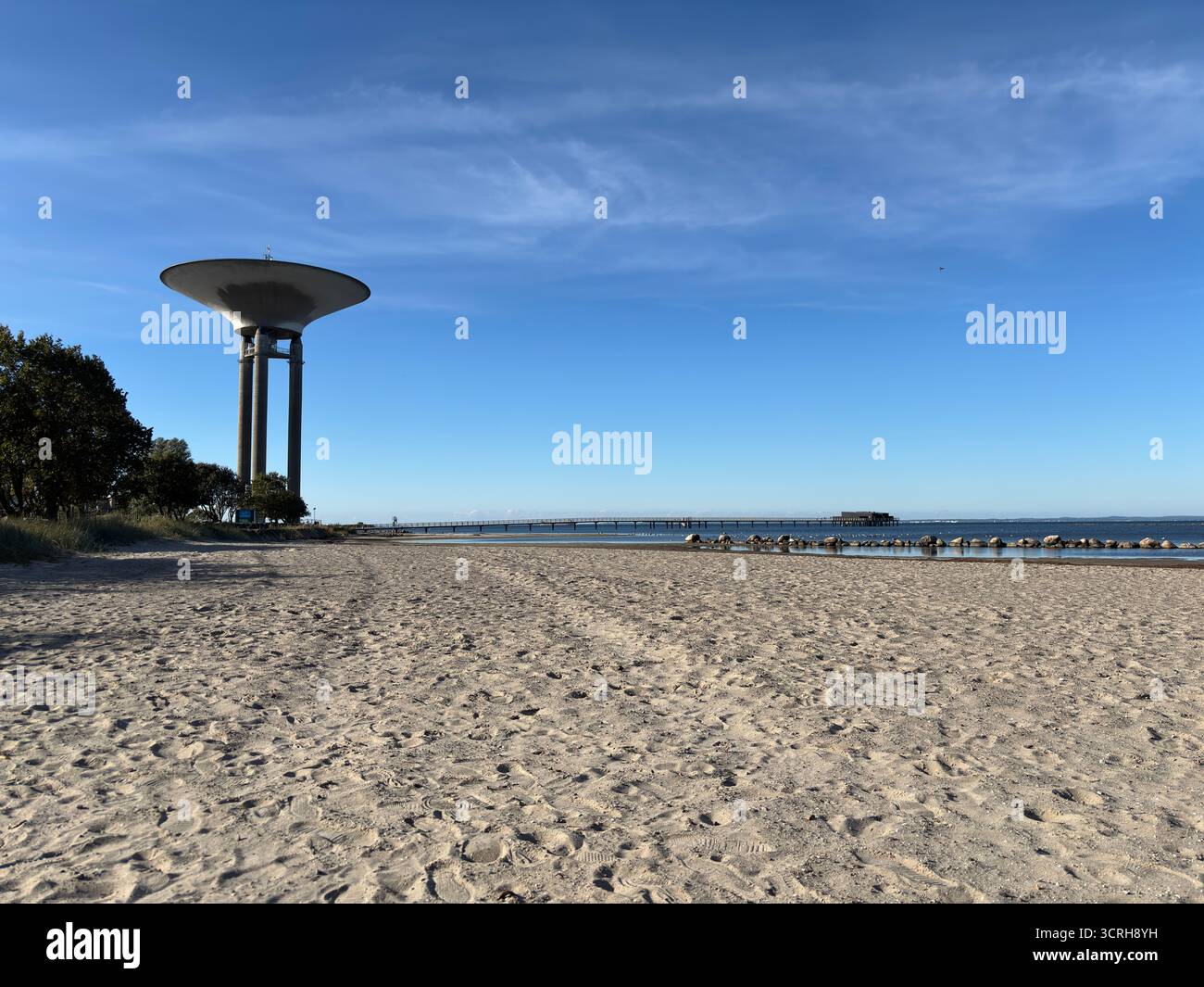 La concrete Landskrona Water Tower in Svezia, costruita nel 1970, presenta un'ampia base di piattini su supporti sottili e un serbatoio visibile sullo skyline costiero Foto Stock