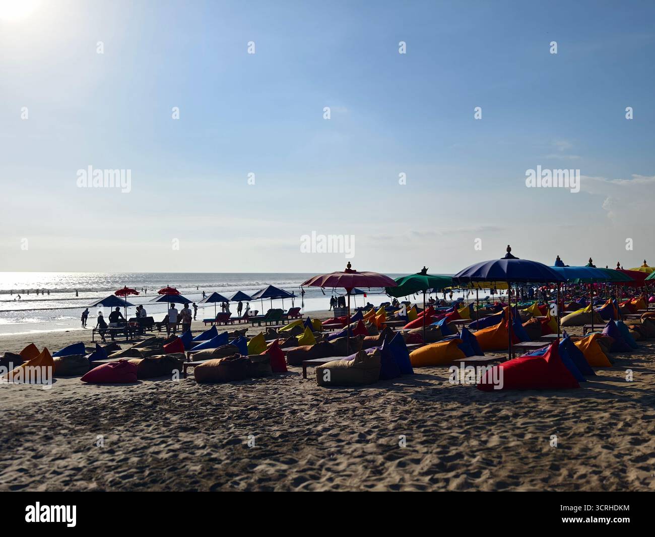 Seminyak, Bali, Indonesia – 28 settembre 2025: Lounge sul mare con sacchi di fagioli colorati e ombrelloni con vista sull'oceano Foto Stock