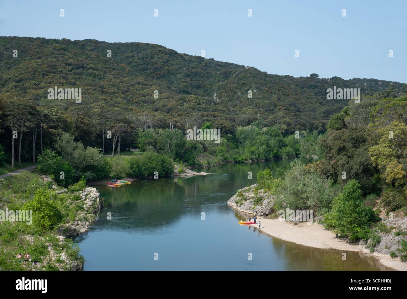 Rive boscose del fiume, spiaggia e canoa del fiume Gardon a monte del Pont du Gard Remoulins Gard Francia Foto Stock