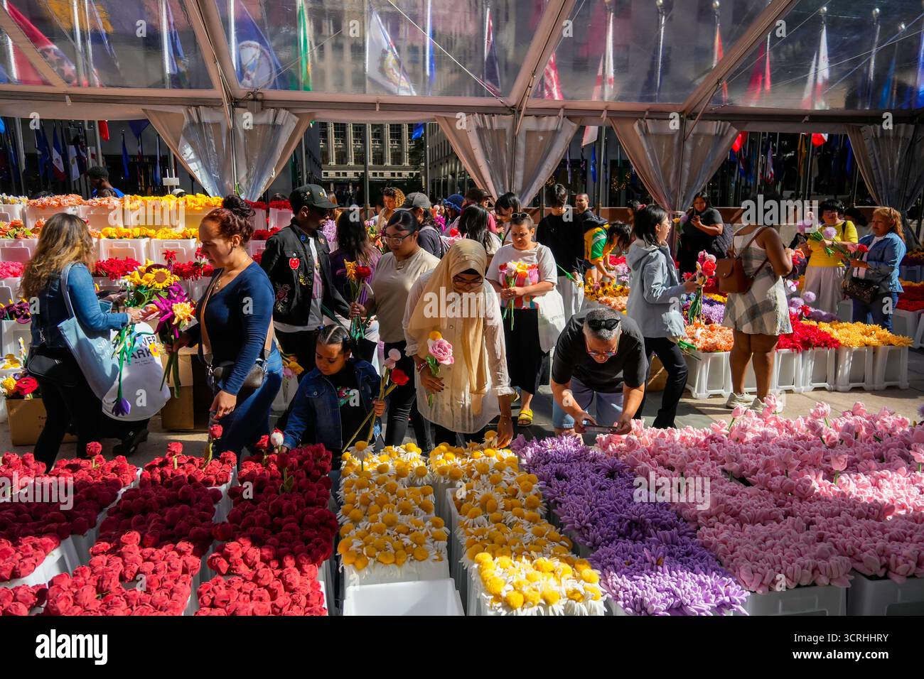 Gli acquirenti scelgono i fiori di peluche nell'immersiva installazione artistica, Flower Market 2,0, dell'artista australiano CJ Hendry al Rockefeller Center di New York sabato 20 settembre 2025. I partecipanti dopo le ore di attesa online hanno ricevuto un fiore gratuito con la possibilità di acquistare altri per completare i loro mazzi. (© Richard B. Levine) Foto Stock