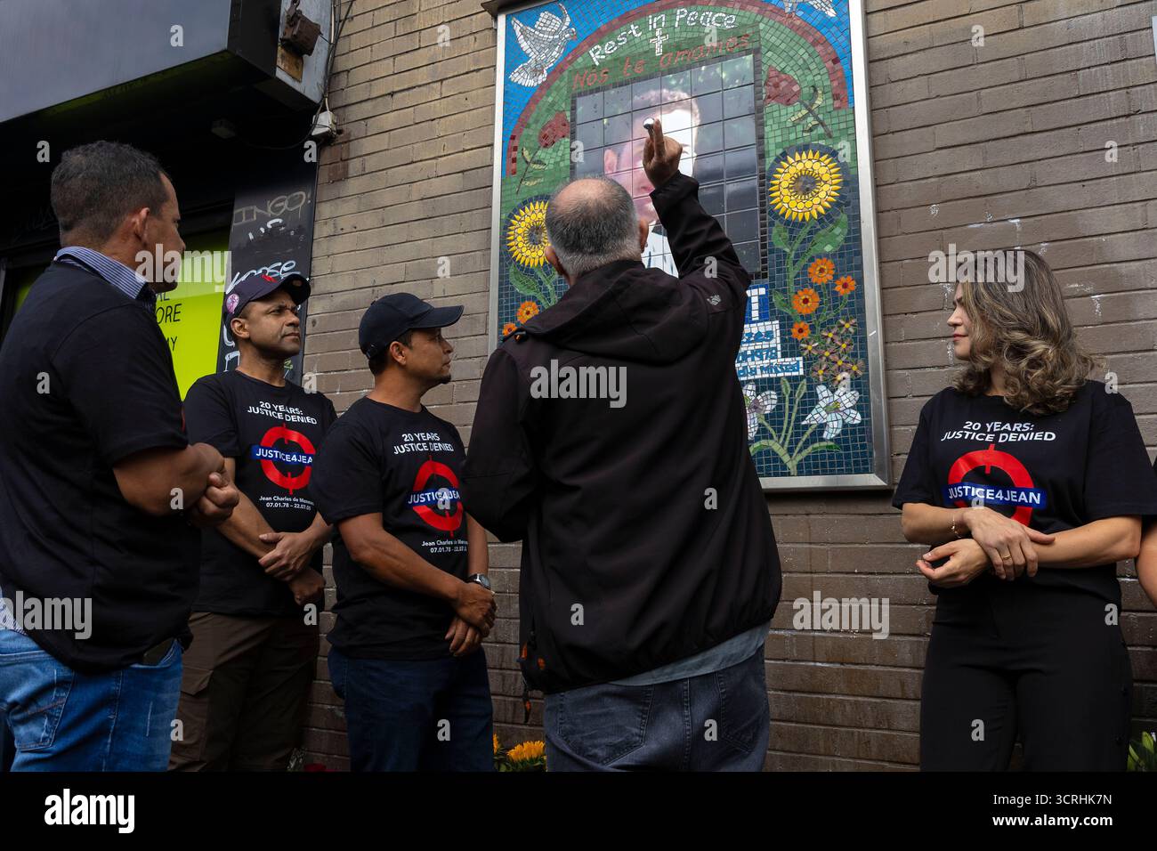 I parenti di Jean Charles de Menezes si trovano al suo memoriale fuori dalla stazione della metropolitana di Stockwell nel sud di Londra mentre si riuniscono per una veglia in segno di 20 Foto Stock