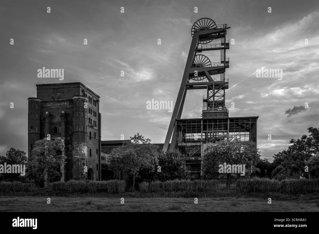 Storica torre mineraria industriale al tramonto - monumento architettonico abbandonato con struttura in acciaio e cielo atmosferico Foto Stock