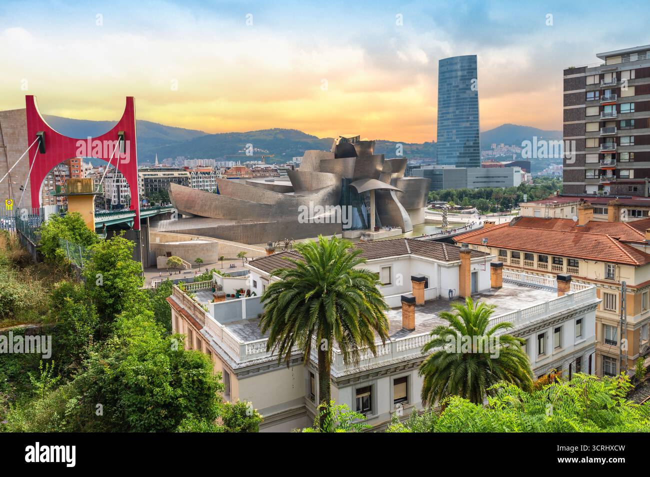 Bilbao, Spagna - 17 luglio 2025: Skyline di Bilbao al tramonto. Foto di viaggio colorate con il Museo Guggenheim, il ponte la Salve e gli edifici Foto Stock