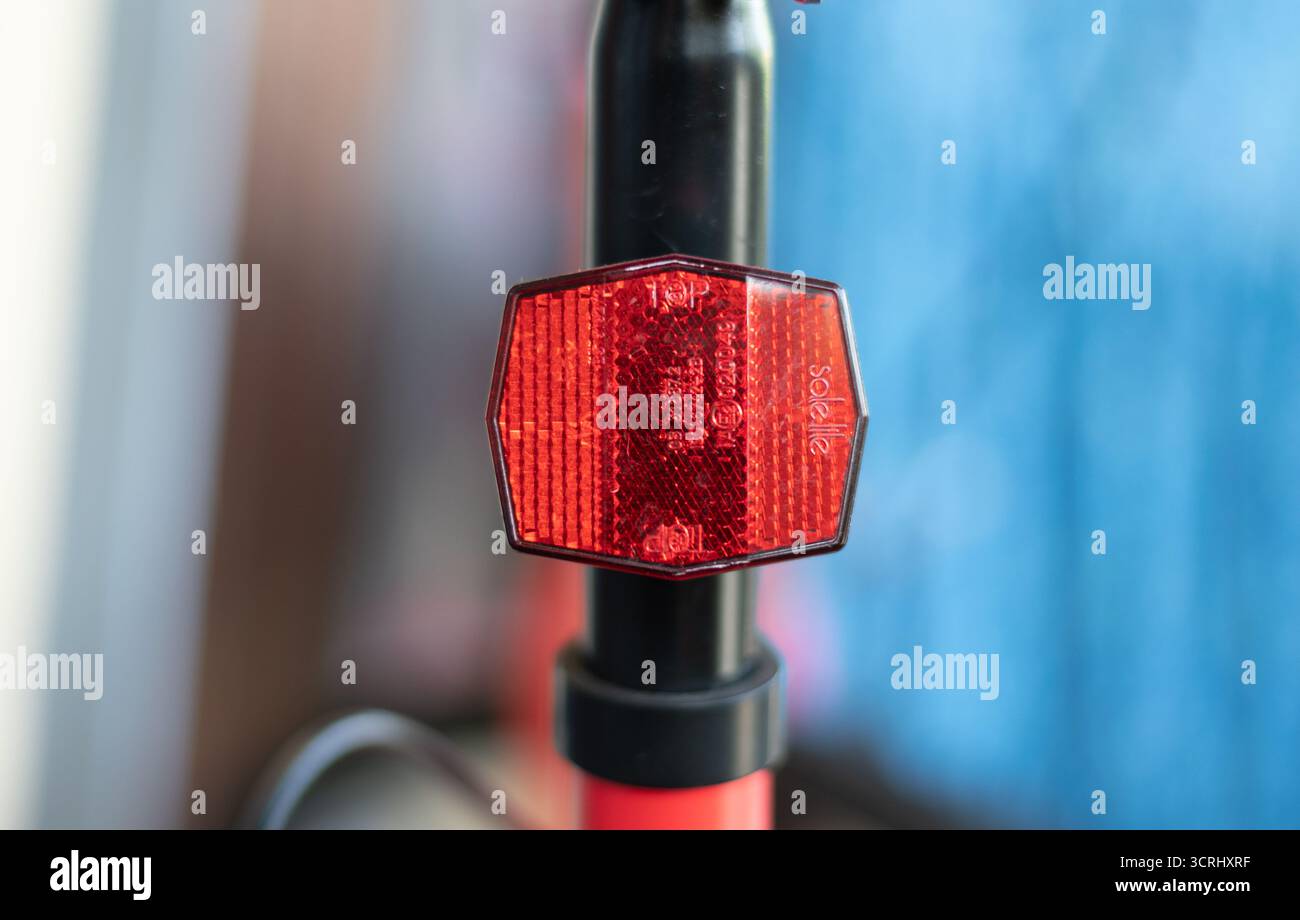 Catarifrangente posteriore rosso per una maggiore sicurezza durante le ore notturne. Soluzione di visibilità passiva per ciclisti e pendolari. Foto Stock
