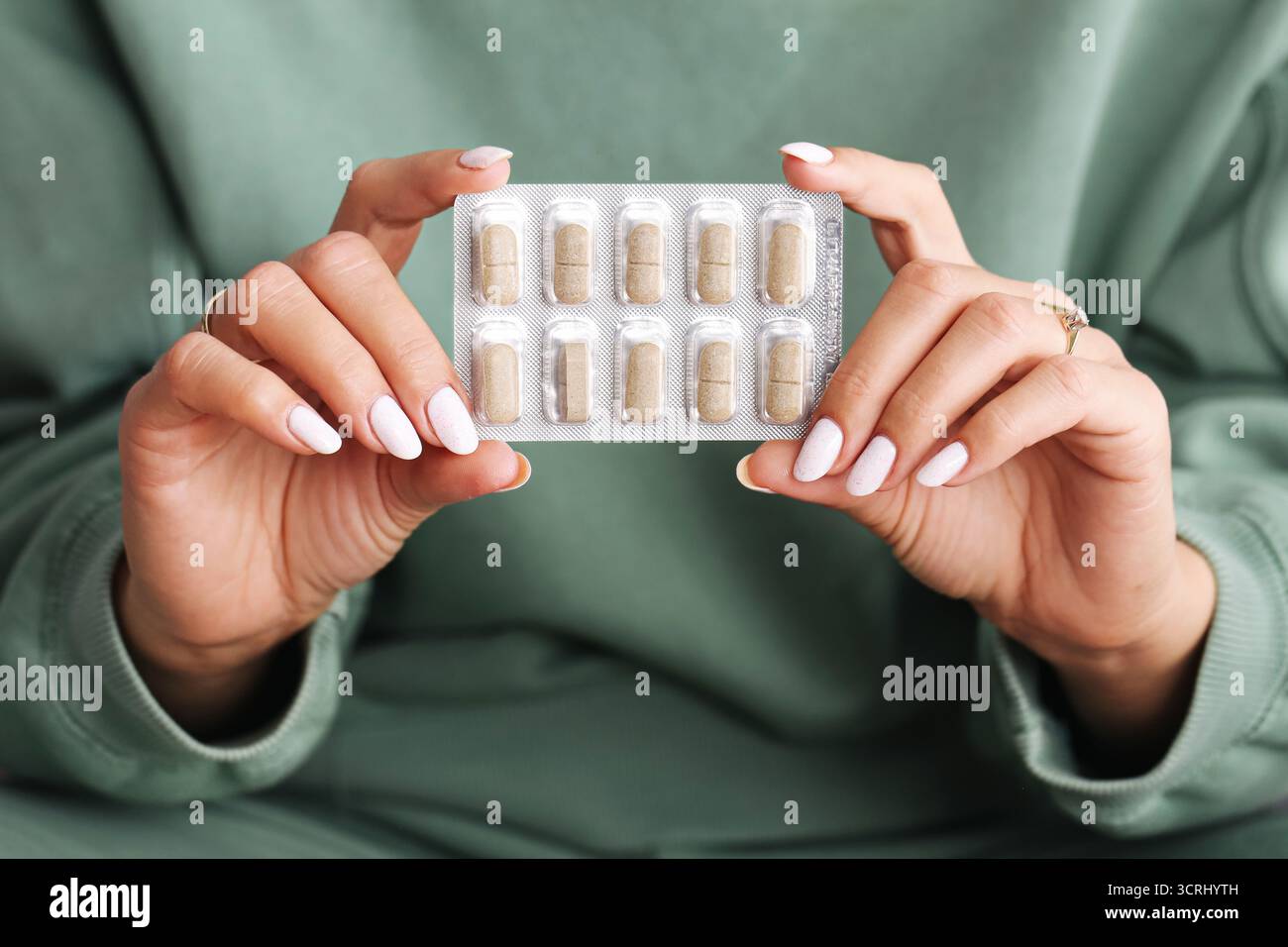 Donna con blister di capsule. Mani con pillole in confezione di fogli di alluminio. Concetto di assunzione di farmaci, integratori o vitamine. Contesto sanitario. Foto Stock