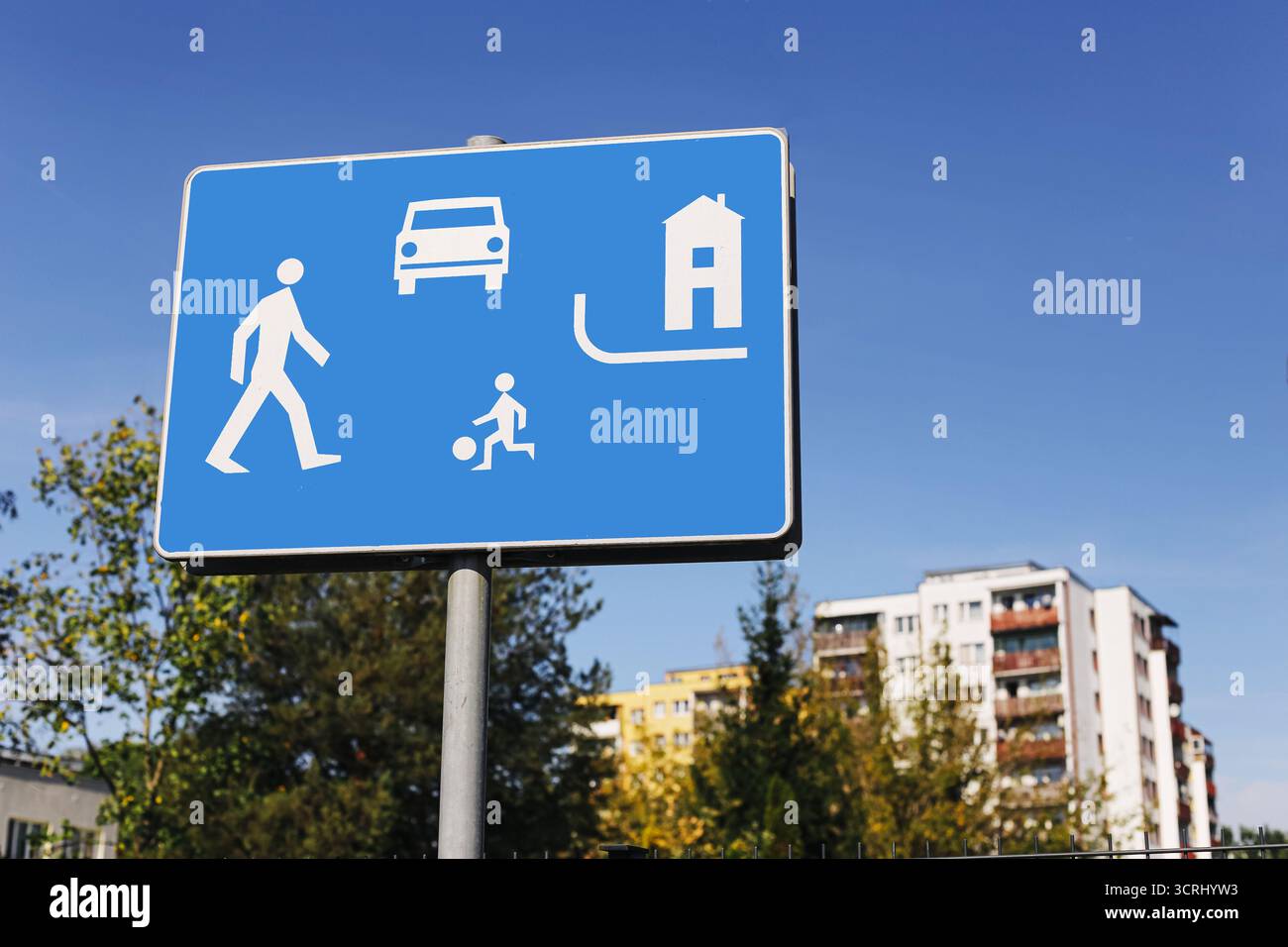 Cartello stradale blu con il simbolo della zona residenziale. codice del traffico con icona pedonale e bambino. Dettaglio sicurezza stradale urbana. Vista esterna dell'edificio Foto Stock