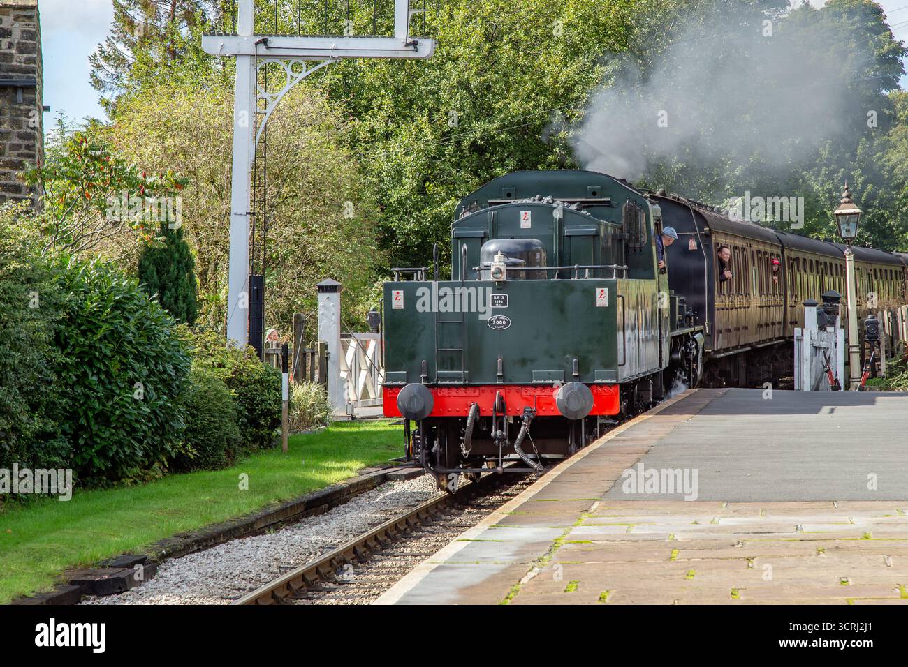 Un treno a vapore (locomotiva) in retromarcia che porta carrozze nella stazione di Oakworth sulla Keighley and Worth Valley Railway Line nello Yorkshire. Foto Stock