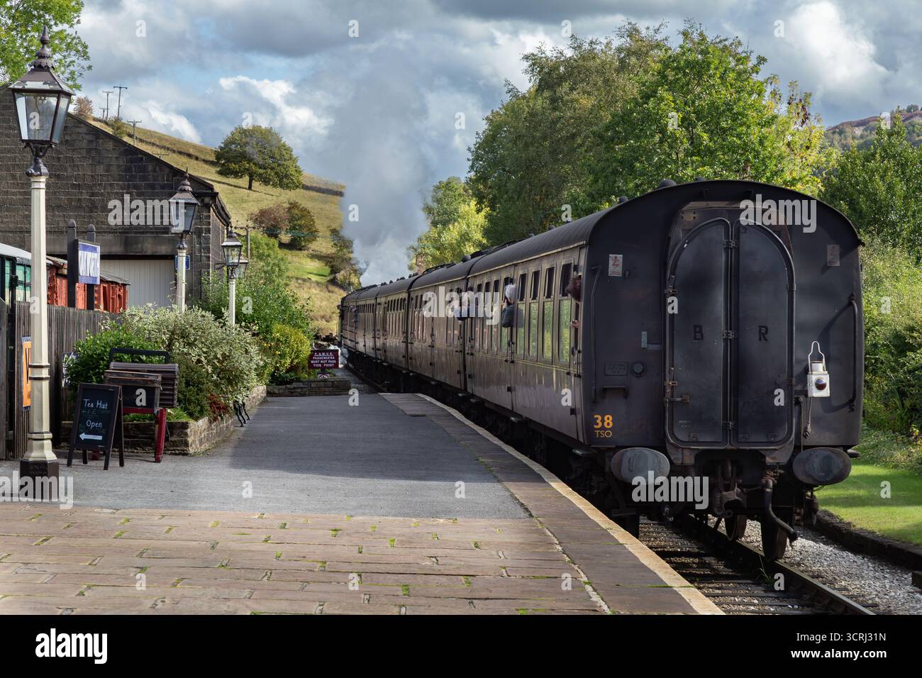 Un treno a vapore che parte dalla stazione ferroviaria di Oakworth, nello Yorkshire, una delle location per i film "Railway Children". Keighley and Worth Valley Railway. Foto Stock