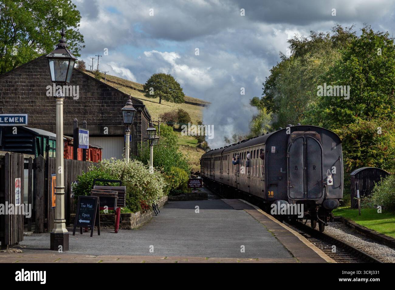 Un treno a vapore che parte dalla stazione ferroviaria di Oakworth, nello Yorkshire, una delle location per i film "Railway Children". Keighley and Worth Valley Railway. Foto Stock