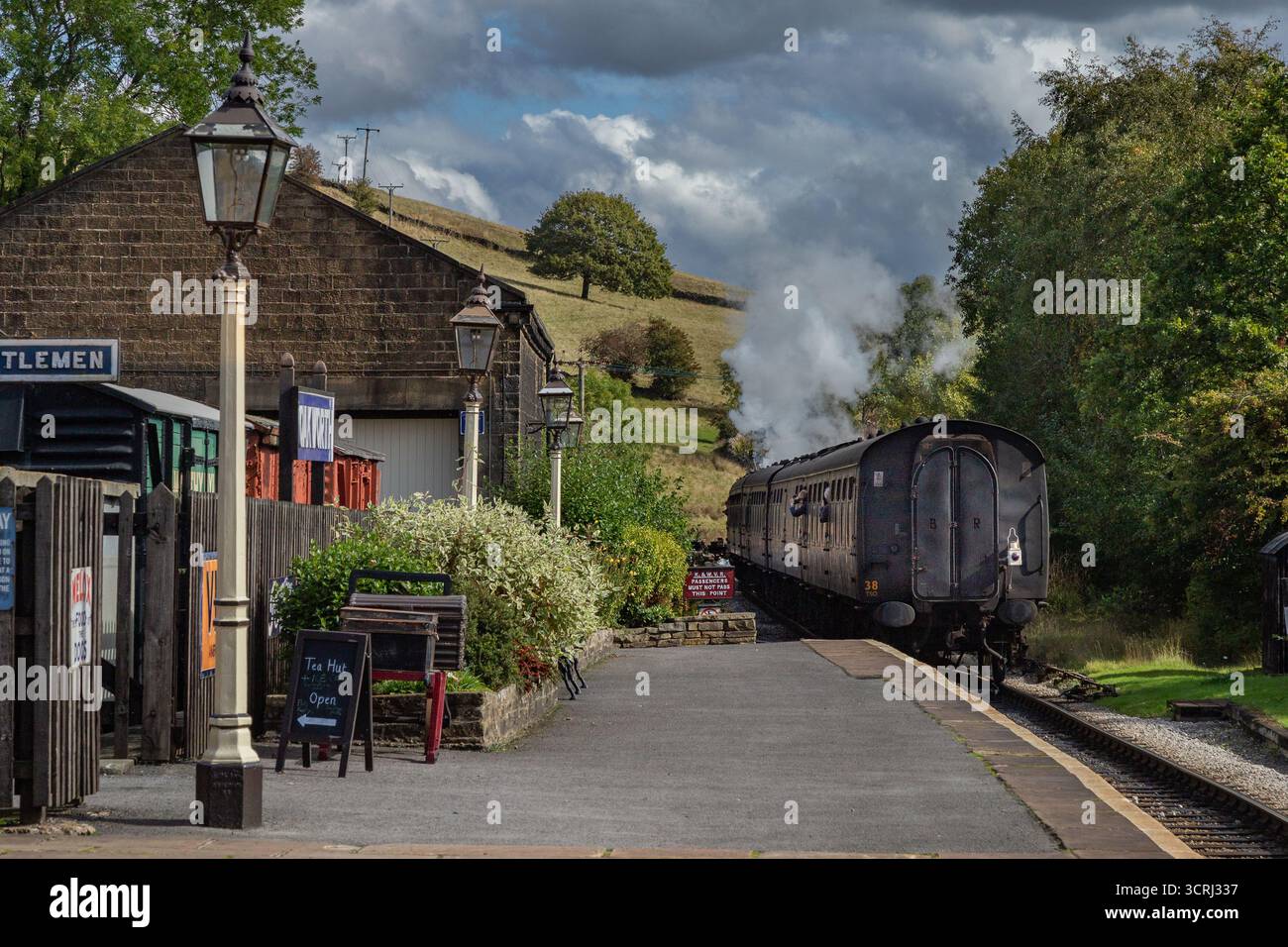 Un treno a vapore che parte dalla stazione ferroviaria di Oakworth, nello Yorkshire, una delle location per i film "Railway Children". Keighley and Worth Valley Railway. Foto Stock