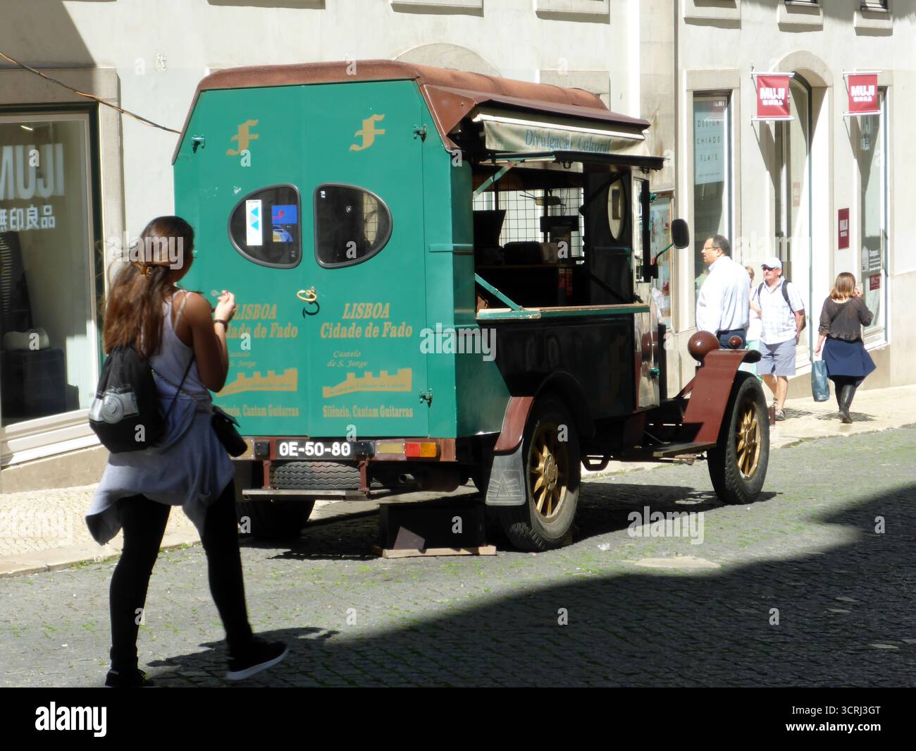 Lisbona, Portogallo - 9 marzo 2017 donna che cammina in direzione di un negozio speciale. E' un camion d'epoca ristrutturato dove vengono venduti i cd Fado Foto Stock