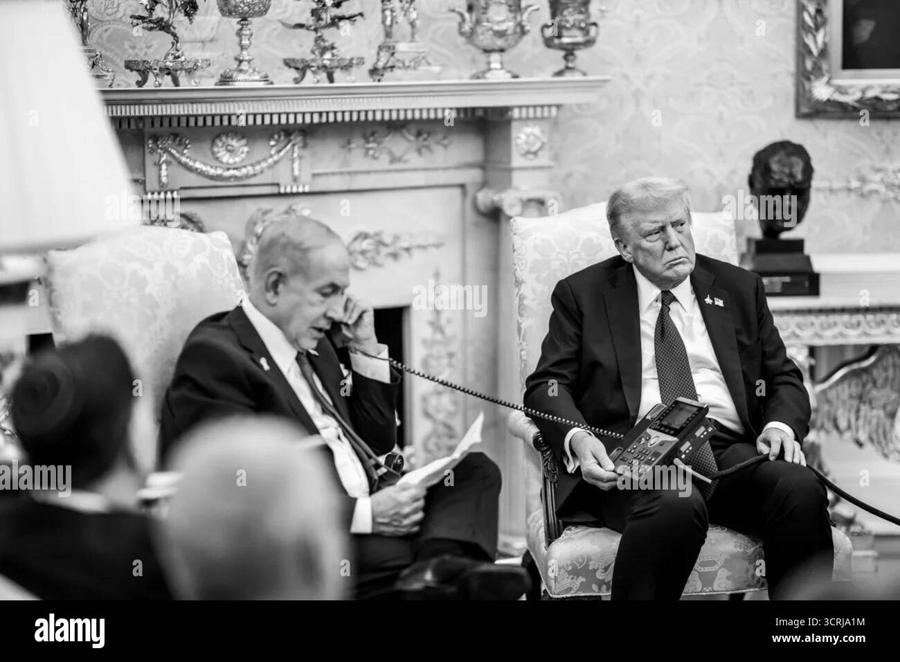 Il primo ministro israeliano Benjamin Netanyahu parla per telefono mentre l'ex presidente degli Stati Uniti Donald Trump ascolta durante un incontro presso l'Ufficio ovale alla Casa Bianca di Washington, DC il discorso è stato prima della loro conferenza stampa congiunta che annunciava il piano di pace degli Stati Uniti per Gaza, intitolato "Pathways to Peace: Gaza 2030". Settembre 2025. Per gentile concessione della Casa Bianca. Foto Stock