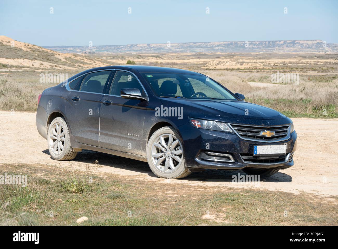 Una berlina nera Chevrolet Impala parcheggiata su una strada sterrata in un paesaggio rurale. Foto Stock