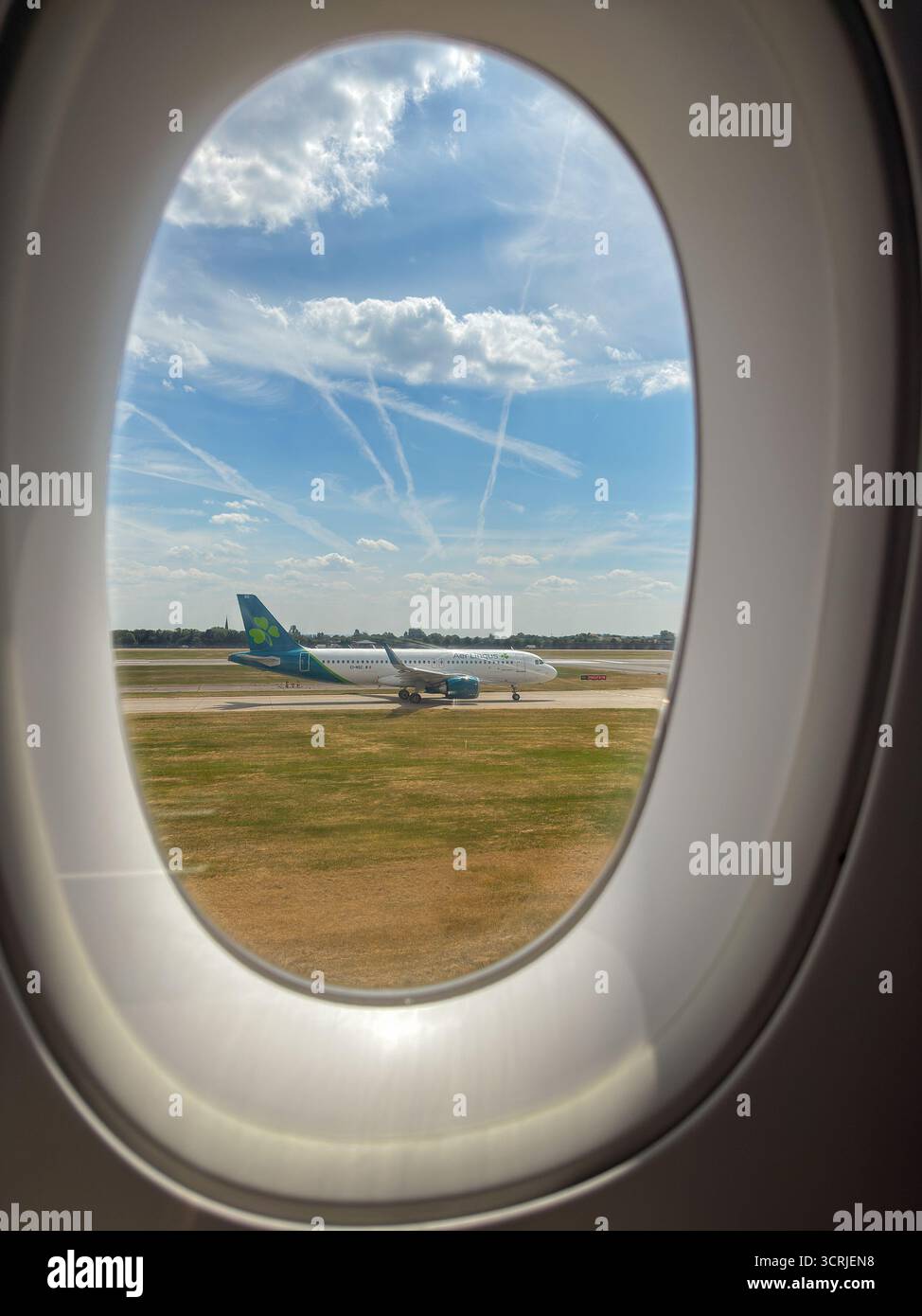Londra, Inghilterra, Regno Unito - 19 maggio 2025: Aer Lingus Airbus jet visto dalla finestra di un altro aereo - Immagine stock catturata con smartphone