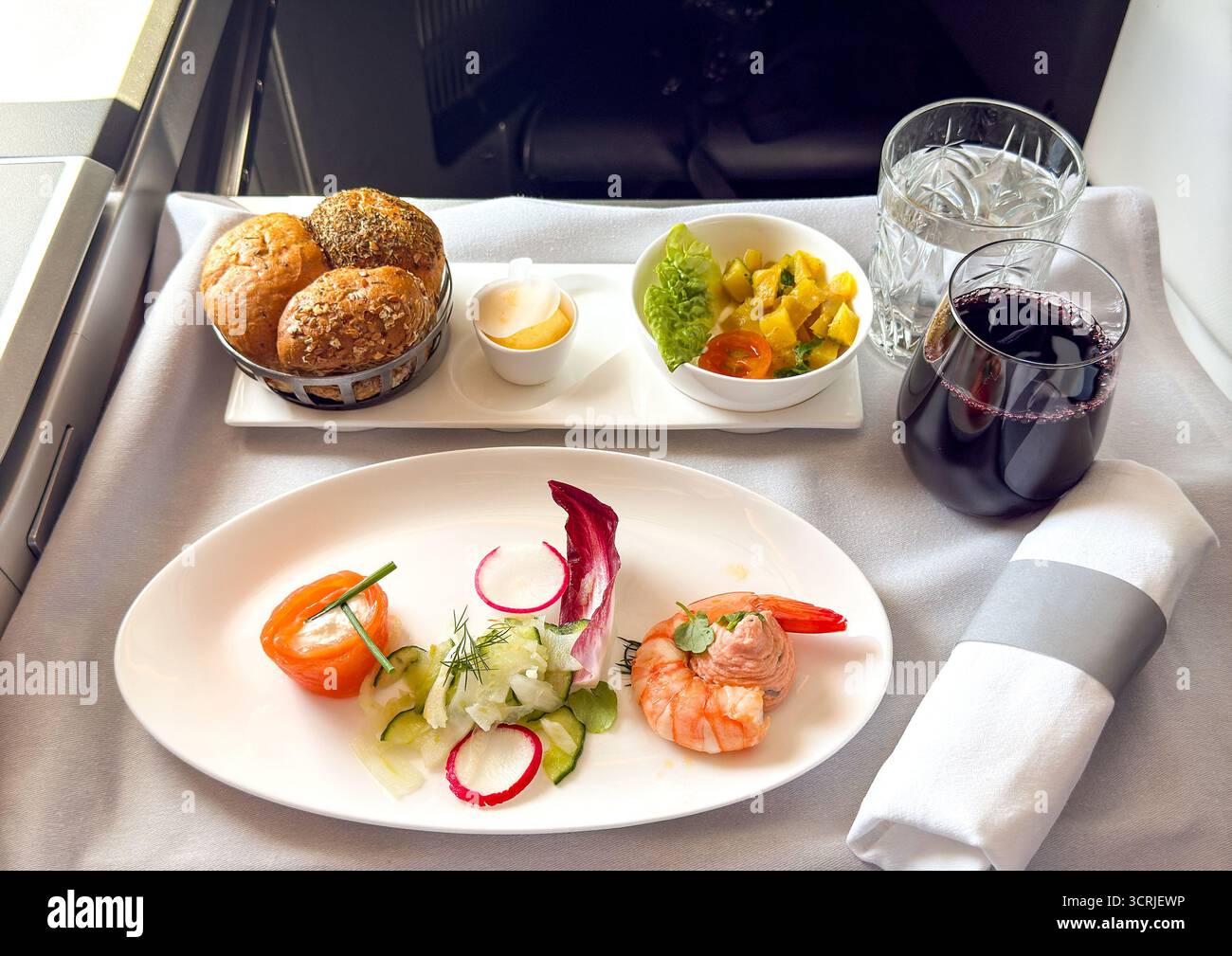 Prima portata di un pranzo nella cabina business class di un jet passeggeri - Immagine stock catturata con smartphone