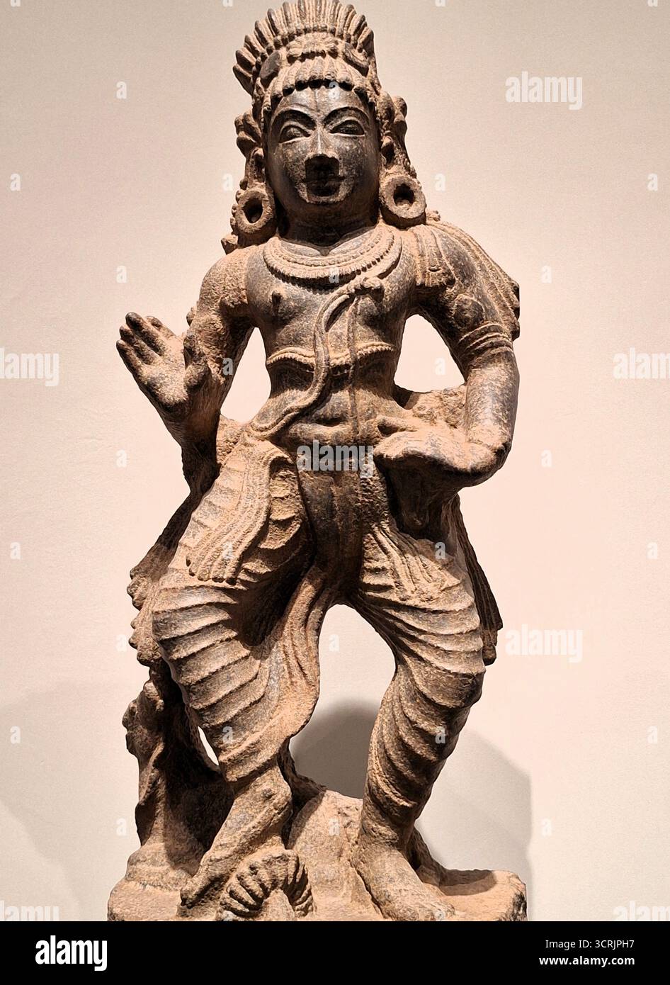 Primo piano verticale di un'antica statua di un Krishna danzante, un'incarnazione del dio Vishnu nella mitologia indù indiana Foto Stock