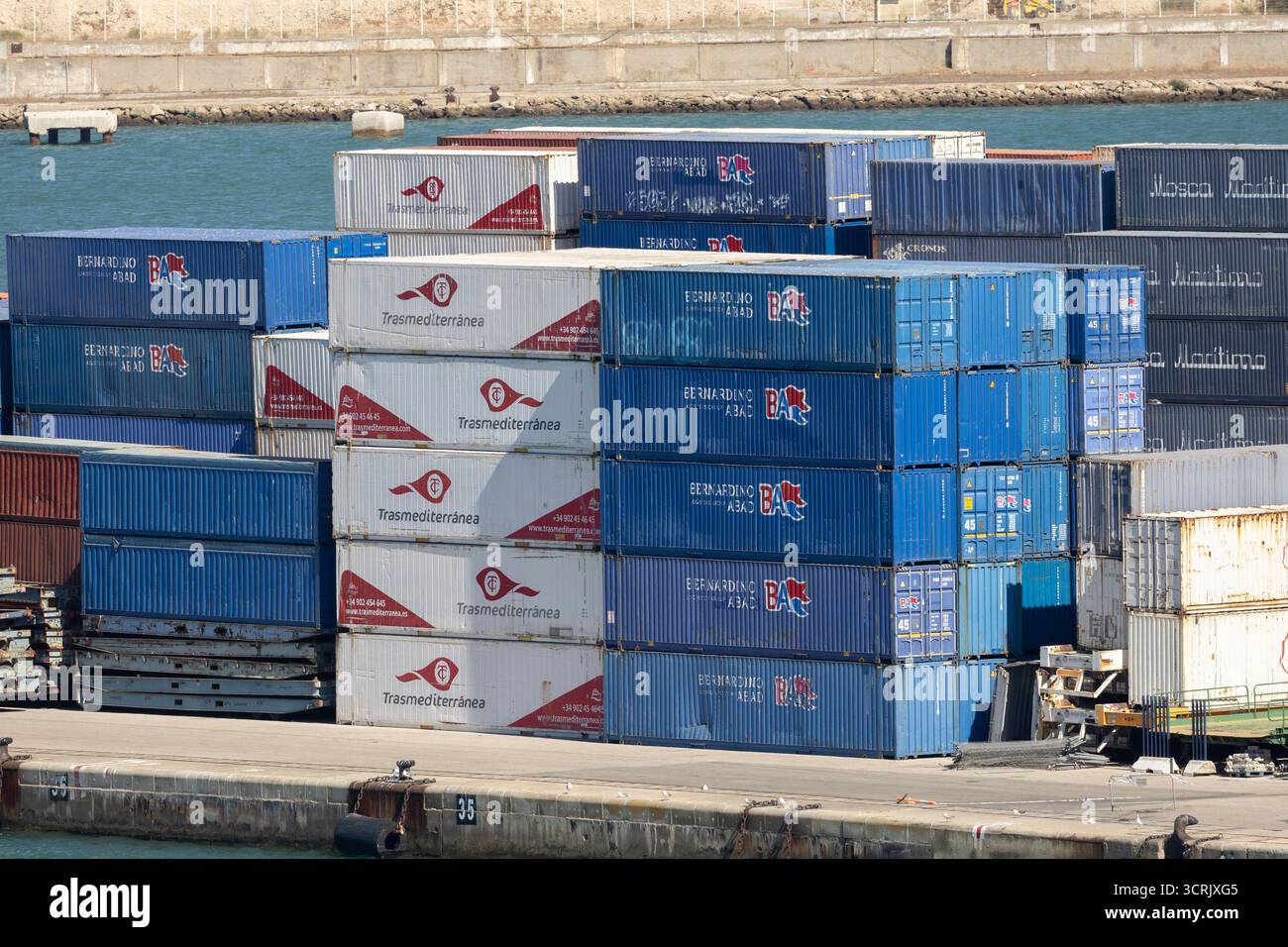 Barcellona, Catalogna, Spagna, 10 settembre 2025, pile di container blu e rossi in un porto trafficato, porto industriale Foto Stock