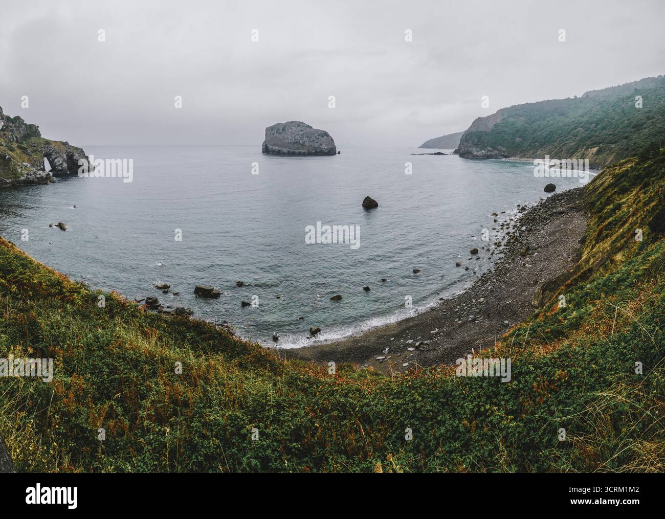 Baia costiera selvaggia tra San Juan de Gaztelugatxe e Bermeo, Paesi Baschi, Spagna. Rocky Beach, Green Cliffs, Oceano Atlantico, costa settentrionale Foto Stock