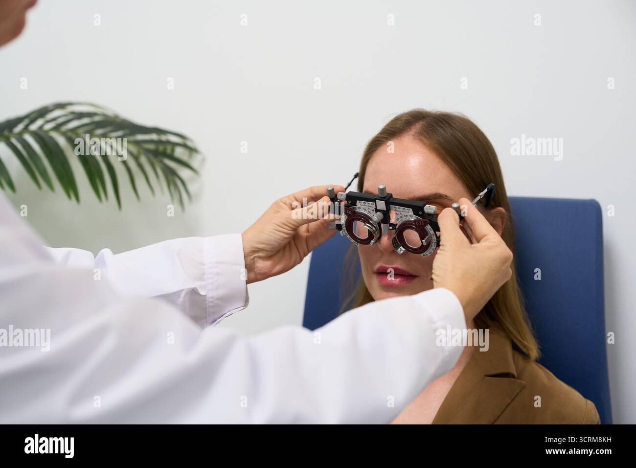 Optometrista che esegue l'esame oculare su pazienti con fanotrofio Foto Stock