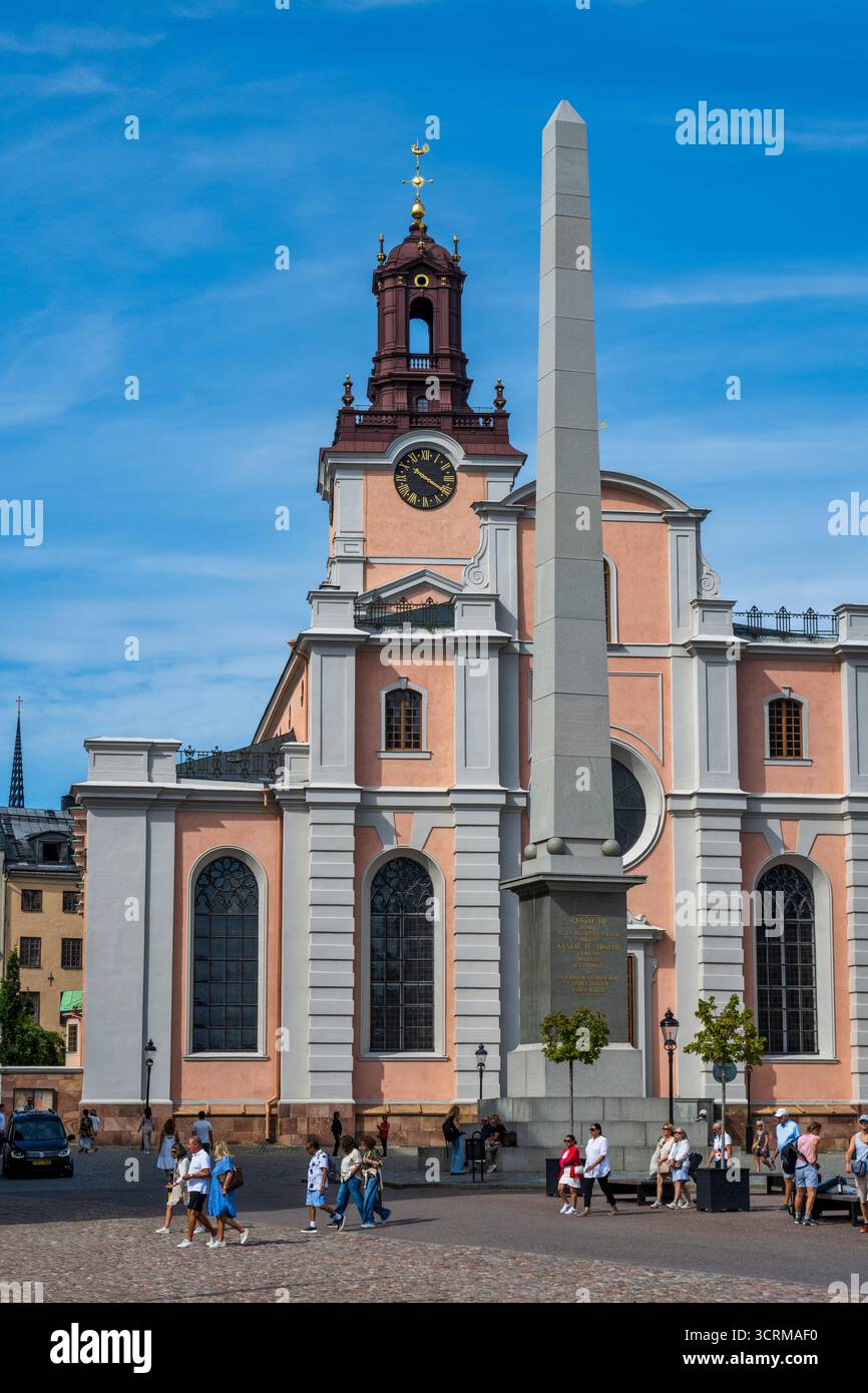 Gustavo III Obelisco a Slottsbacken, con la Cattedrale di Stoccolma (Storkyrkan) sullo sfondo nella città vecchia di Stoccolma (Gamla Stan) in Svezia, Nord Europa Foto Stock