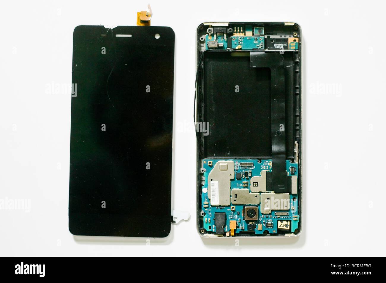 Primo piano di smartphone con componenti hardware rotti e schermo LCD isolato su sfondo bianco Foto Stock